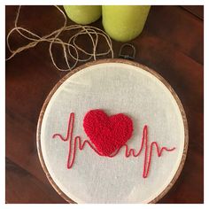 a red heart on a white embroidery hoop