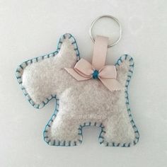 a keychain shaped like a dog with a bow on it