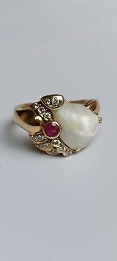 This 14k gold Vintage ring is one of a kind. The solid piece is an eye catcher and was handmade & most likely also a costume piece. The big mother of pearl is adorned with diamonds and a ruby. The surface of the ruby has signs of wear! Inner diameter: 15,5mm x 16,5mm Weight: 5,46gr Approx. size: US 5.7, UK K 1/2, De 51 The pictures are a part of the description & they are enlarged for a better description! Please also have a look at wearing pictures and the dimensions!  The boxes in the pictures Gold Vintage Ring, Mother Of Pearl Ring, Ruby Diamond, Vintage Ring, Pearl Ring, Rings Statement, Crystal Jewelry, Vintage Rings, Antique Jewelry