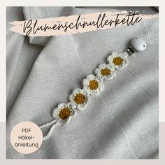 a crocheted bracelet with sunflowers is shown on top of a bed