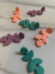 six pairs of colorful earrings sitting on top of a counter