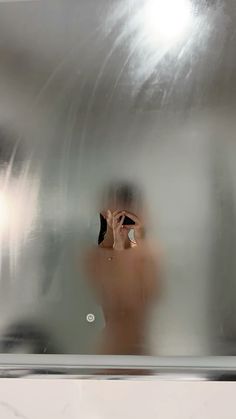 a person taking a photo in front of a mirror with their reflection on the wall