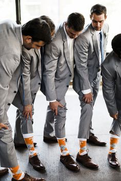 a group of men in suits and socks standing next to each other with their feet on the ground