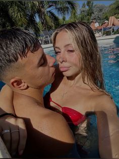 a man and woman kissing in the pool