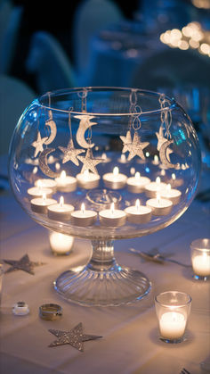 A wedding table centerpiece with a moon and stars theme is lit up by tealight candles. Tall Greenery Centerpieces, Wedding Outline, Candlelight Wedding, Greenery Centerpieces, Unique Wedding Centerpieces, Wedding Centerpiece Ideas, Summer Wedding Ideas, Candle Lit Wedding, Celestial Decor