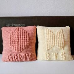 two crocheted pillows sitting on top of a couch