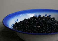 a blue and white bowl filled with black beans