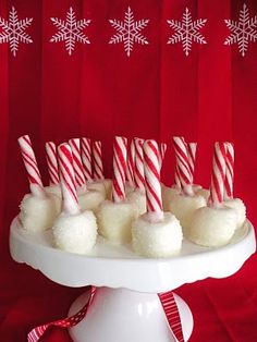 a white cake plate topped with lots of candy canes and marshmallows