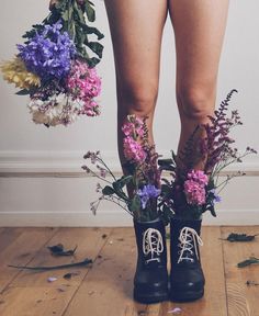 a person standing with flowers in their boots