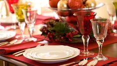 a table set for christmas dinner with silverware and red napkins