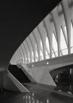 the interior of a modern building with stairs and light coming from it's windows