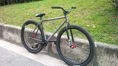 a bike parked on the side of a road next to a grass covered park area