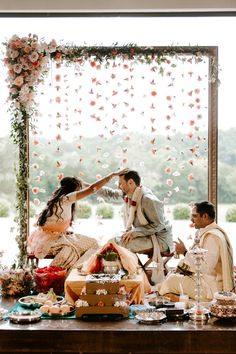 a bride and groom feeding each other cake at their wedding reception in front of an open window