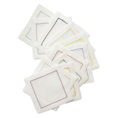 six white napkins with different colored stitching on them