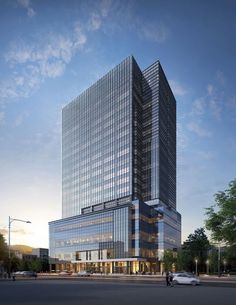 an artist's rendering of the exterior of a modern office building at dusk, with cars parked in front