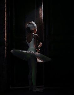 a young ballerina is standing in the dark