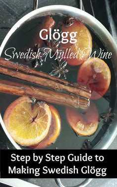 a pot filled with liquid next to cinnamon sticks and oranges on top of a stove