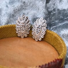 ༺♥༻✧OPEN FOR DESCRIPTION✧༺♥༻ Art Deco Style Sterling Silver (Rhodium Plated) Marcasite Screw Back Earrings with Oval Floral Form. Overall in excellent pre-loved condition, shows minimal surface wears and shiny rhodium coating appears to have no tarnishes. Rhodium plated sterling silver is considered more desirable since it is less likely to tarnish, and will appear shinier with a mirroring effect, which will also enhance the appearance of any gemstones or details on the jewelry. Screw backs are easy to adjust to your comfort, as they will not pinch or pull your earlobes while clip-ons and pierced backs may do so. Art Deco style screw back earrings made by 1990s jewelry designer Masha. Full set of marcasites, no missing stones. - Marked "Sterling" and "MASHA" - Full Length measures 6/8 inch Luxury Silver Marcasite Jewelry, Vintage Marcasite Jewelry, Marcasite Earrings Art Deco, Minimal Surface, Romantic Jewelry, Romantic Jewellery, Sterling Silver Marcasite, Screw Back Earrings, Jewelry Vintage