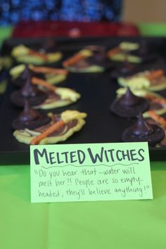 there is a sign that says melted witches on the table next to some cookies and candies