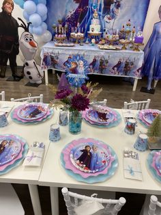 the table is set for a frozen princess birthday party with balloons, plates and decorations