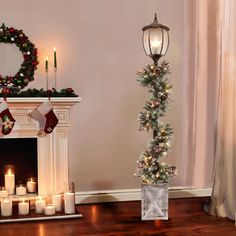 a fireplace with candles and christmas decorations around it