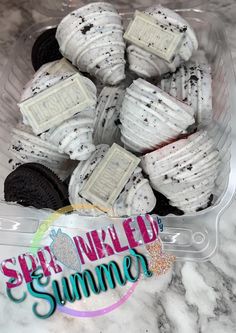 a plastic container filled with white and black cookies