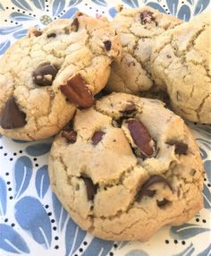 four chocolate chip cookies on a blue and white plate