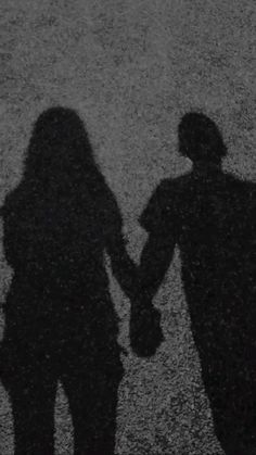 the shadow of two people holding hands