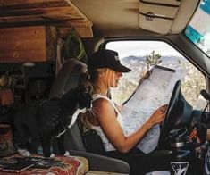 a woman sitting in the back seat of a van looking at a map