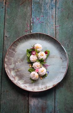 a plate with flowers on it sitting on a wooden table