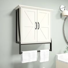 a white cabinet hanging on the wall next to a mirror and sink in a bathroom