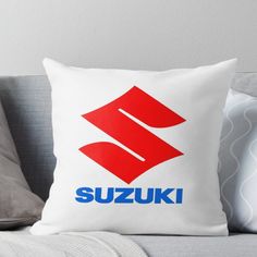 the suzuki logo is displayed on a white pillow with red and blue lettering in it