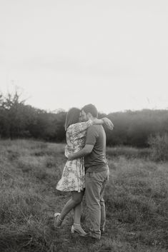 a man and woman hug each other in a field