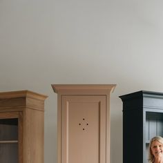 a woman sitting on the floor in front of two cupboards