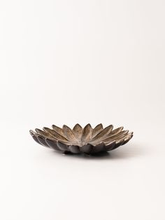 a black and gold plate on a white surface with no one around it or the bowl is empty