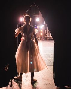 a woman in a dress is standing on a skateboard