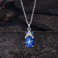 Item description ✦ Handmade, high-quality item! ✦ Material: 925 sterling silver, Solid 14K/18K GOLD (can be made in white/rose/yellow gold), Platinum ✦ Center Stone: 7x9mm Oval Cut Lab Blue Star Sapphire ✦ Side Stones: Round Cut Lab Blue Sapphires ✦ Chain length can be adjusted between 16 inches and 18 inches As it is handmade, it needs 2-4 weeks to finish and then be shipped by USPS or FedEx. Return policy: We offer 30 days return policy. For any reason, if you are not completely satisfied with Celestial Hallmarked Jewelry With Oval Stones, Celestial Style Hallmarked Oval Jewelry, Oval Sapphire Necklace With Hallmark, Silver Oval Celestial Necklace, Celestial Silver Oval Necklace, Silver Celestial Jewelry With Oval Cabochon, Celestial Oval White Gold Jewelry, Celestial White Gold Oval Jewelry, Oval Sapphire Necklace With Polished Finish