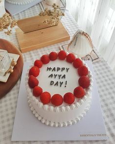 a birthday cake with the words happy aya day written on it, surrounded by other decorations