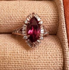 This beautiful ring is a perfect addition to any jewelry collection. Crafted with natural rhodolite garnet in a marquise shape, this ring features a stunning 6mm wide and 12mm long main stone, which is set in rose gold metal. The ring is also adorned with a secondary diamond stones, adding to its elegance. The ring is size 5.5 and can be resized if needed. It is a perfect gift for someone special or can be worn to add a touch of sophistication to any outfit. Don't miss the chance to own this uni Luxury Ruby Marquise Cut Rings, Luxury Ruby Marquise Cut Ring For Formal Occasions, Luxury Ruby Ring Marquise Cut For Formal Events, Luxury Marquise Cut Ruby Ring For Formal Occasions, Luxury Diamond Ring With Marquise Cut Gemstone, Marquise Ruby Diamond Ring, Luxury Diamond Ring With Marquise Cut, Fine Jewelry Ruby Ring With Marquise Halo, Fine Jewelry Marquise Ruby Ring With Halo Setting