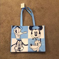 a blue and white bag with mickey mouse on it's side, sitting on the floor