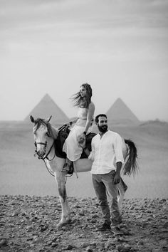 a man riding on the back of a horse next to a woman in a white dress