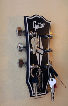 a guitar with keys hanging from it's neck and the name guitar on it