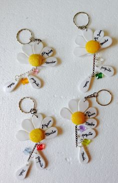 four keychains with flowers and names on them, all hanging from the same chain