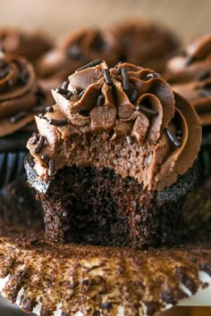 chocolate cupcakes with frosting and sprinkles sitting on a plate