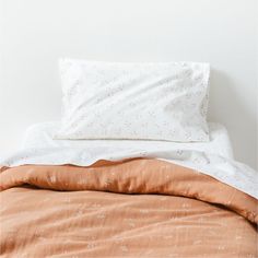 an unmade bed with two pillows on top of it and a pillow case in the middle