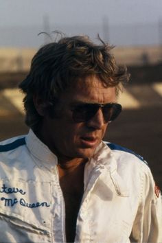 a man wearing sunglasses and a white jacket