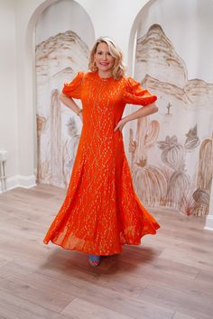 Indulge in the vibrant beauty of the Orange Jacquard Bibi Dress! The gorgeously smocked design with puffball sleeves and a full skirt is enhanced by shimmering gold threads in a diamond pattern. The free fit silhouette offers comfort with a bohemian flair, perfect for any occasion from parties to vacations. Embrace effortless style and radiate confidence in this stunning dress. For a flowing fit, size up one size. If you are petite order your normal size. Lexi is 5’3” and wearing size Small. Sundresses Women, Radiate Confidence, Summer Wedding Guests, Midi Dress Casual, Wedding Guest Dress Summer, Gold Threads, Clothes Collection, Full Skirt, Stunning Dresses