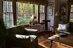 a living room filled with furniture and windows covered in sunlight coming through the window panes