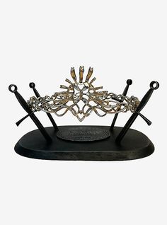 a black and gold tiara with two swords on it's head, in front of a white background