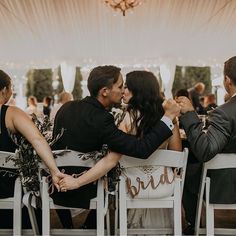 a couple kissing each other while sitting in chairs